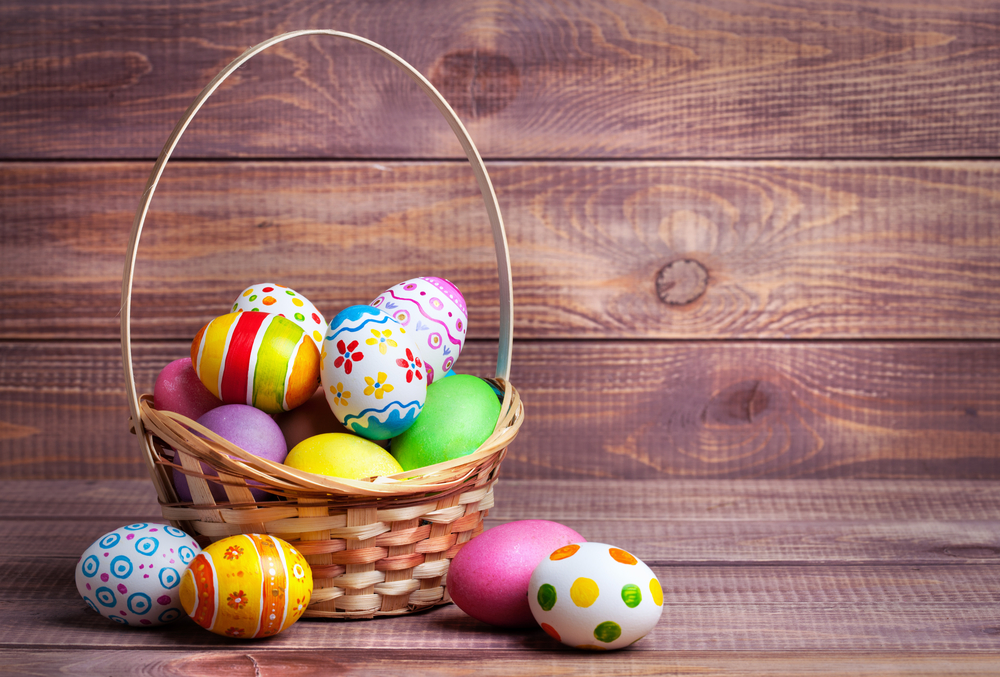 Easter eggs in the basket of wooden boards